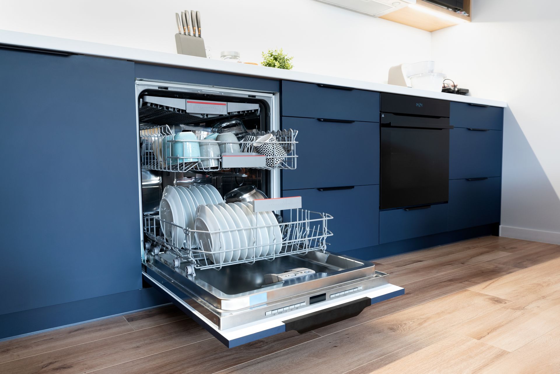 A dishwasher is open in a kitchen with blue cabinets.