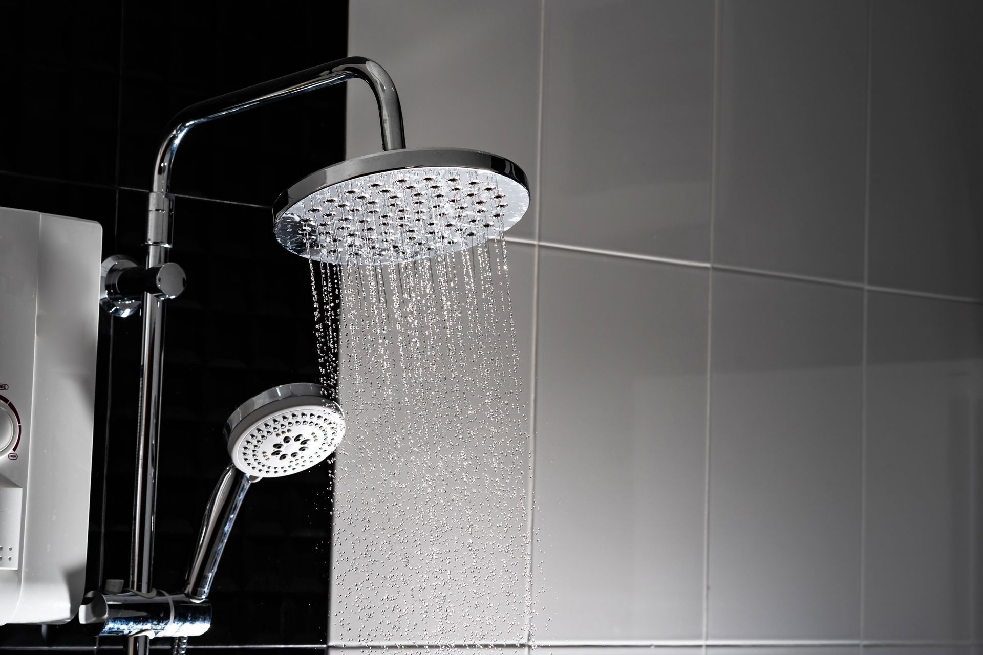 A shower head is spraying water in a bathroom.