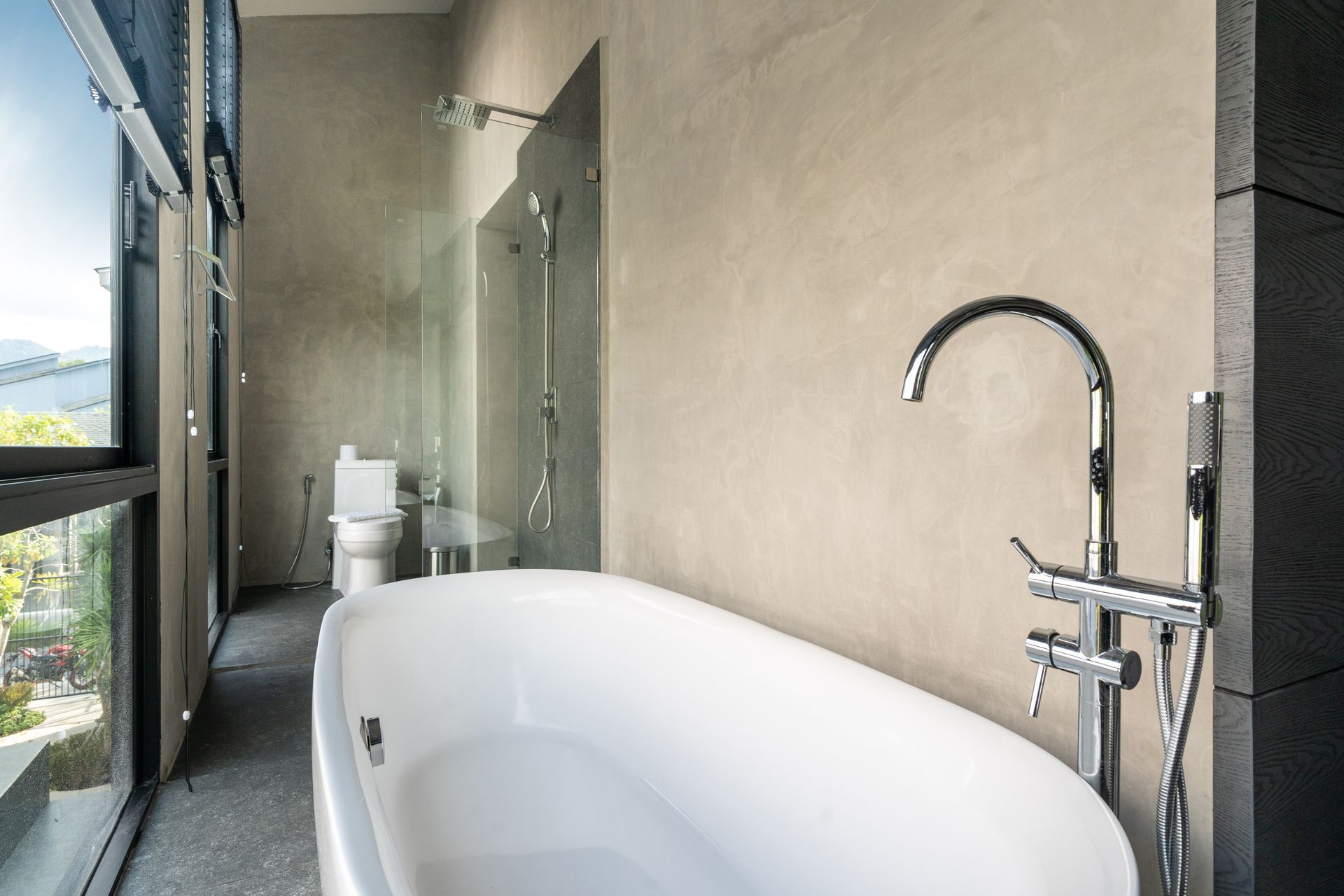 A bathroom with a bathtub , toilet and shower.