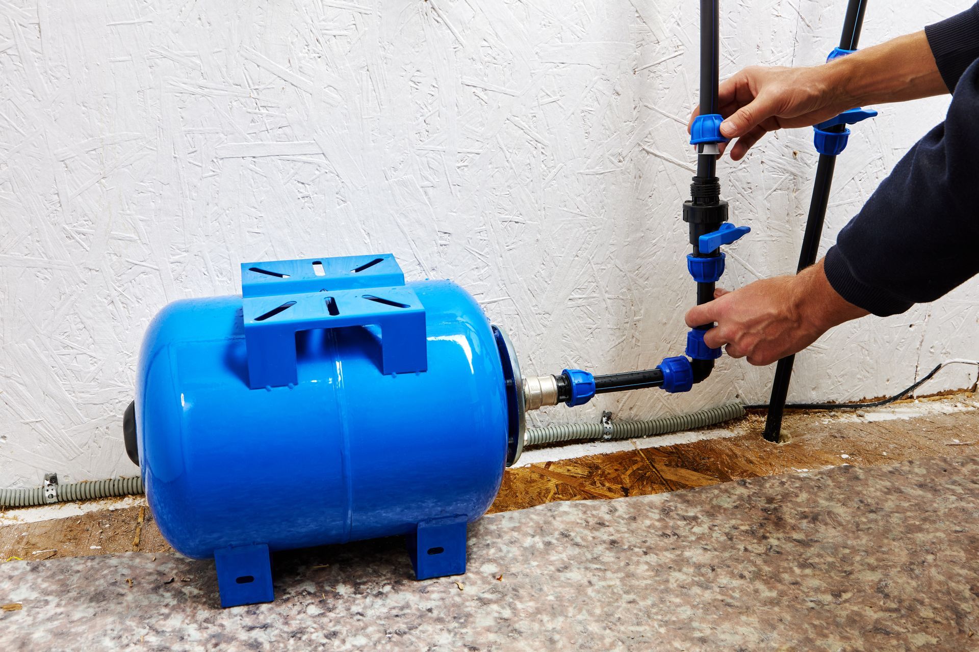 A person is installing a water pump on the ground.