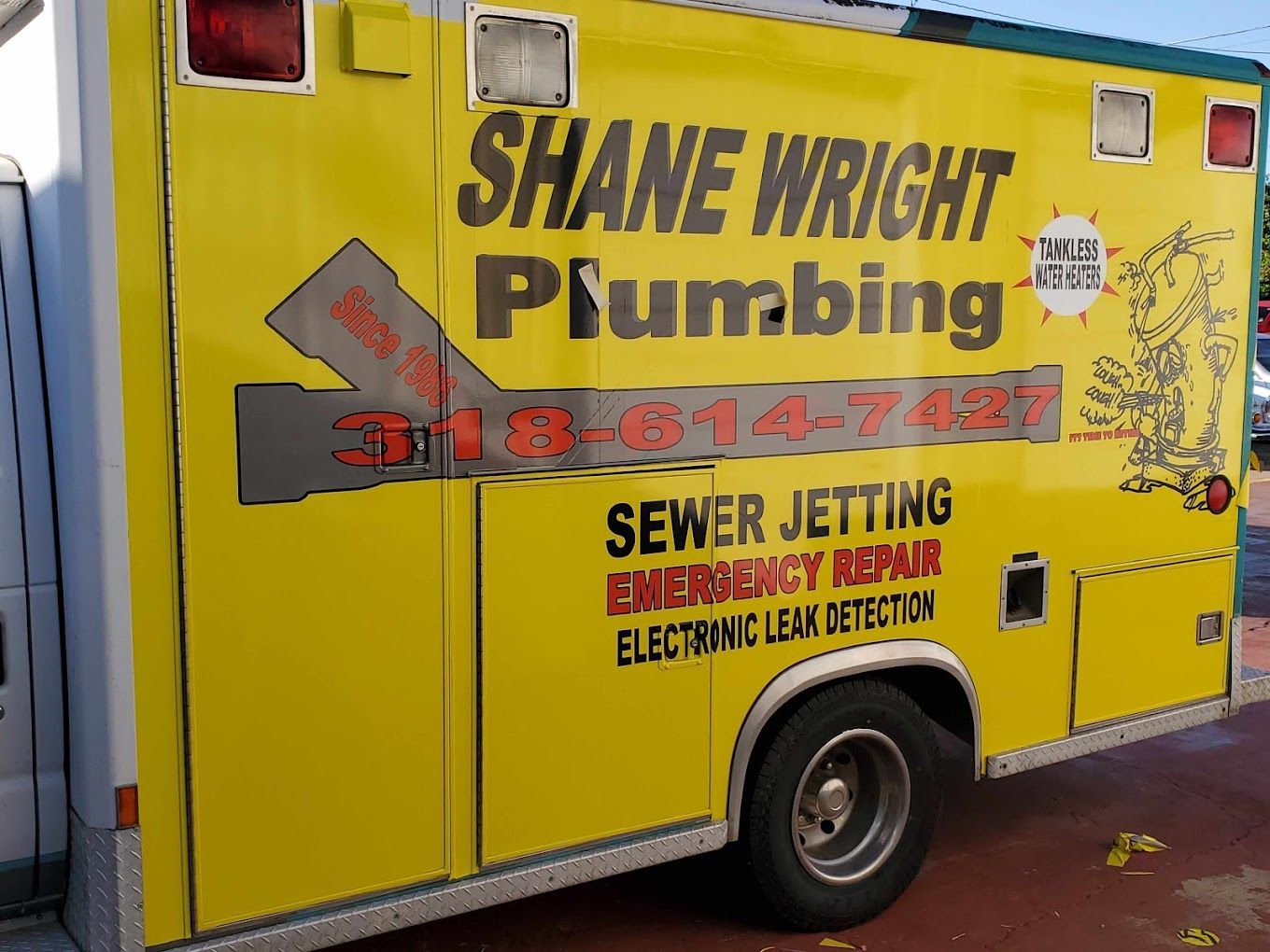 A yellow shane wright plumbing truck is parked on the side of the road