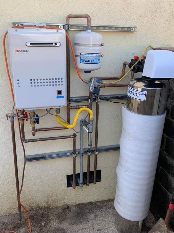 A water heater is attached to a wall next to a water filter