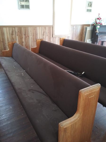 A row of benches in a church with brown cushions