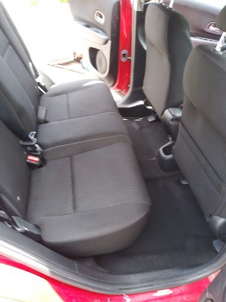 The back seat of a red car with black seats