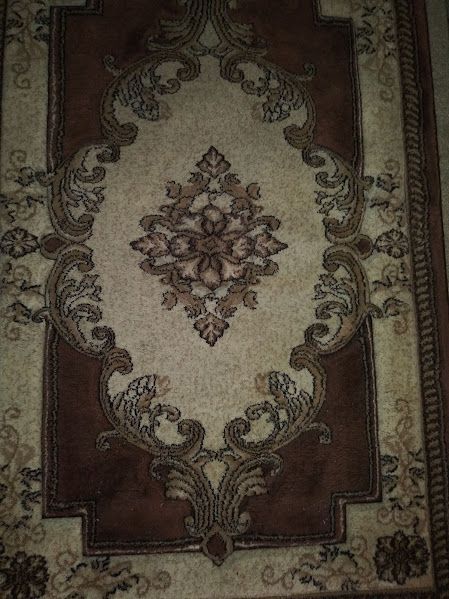 A brown and white rug with a floral pattern on it