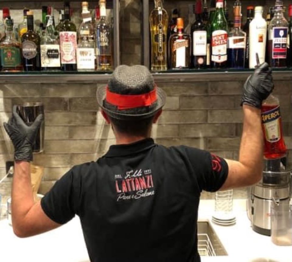 Un uomo che indossa un cappello e una maglietta con la scritta