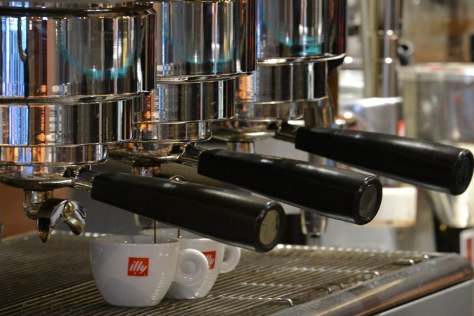 Due tazze illy sono appoggiate su una macchina per il caffè