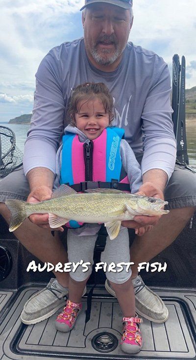 fisherman and a small child holding her catch