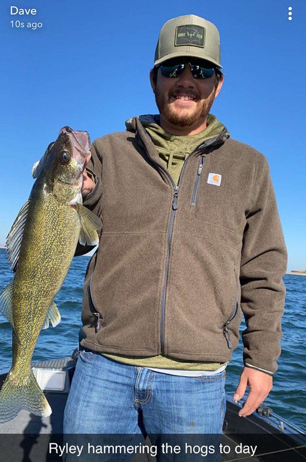 man in brown sweatshirt holding fish