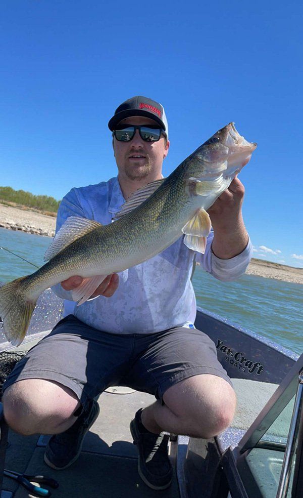 man in baseball cap holding fish