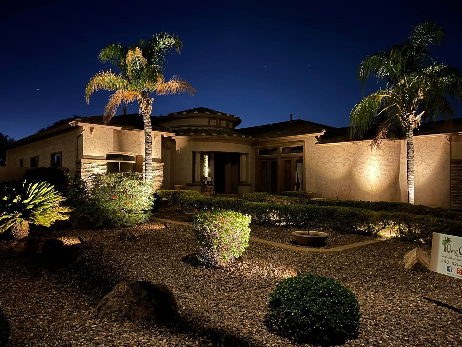 Raised garden bed with arched supports, lush green plants, and a brick patio.