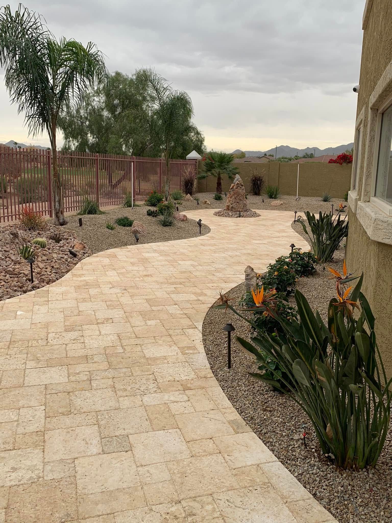 Desert landscape with cacti, rocks, and agave plant.