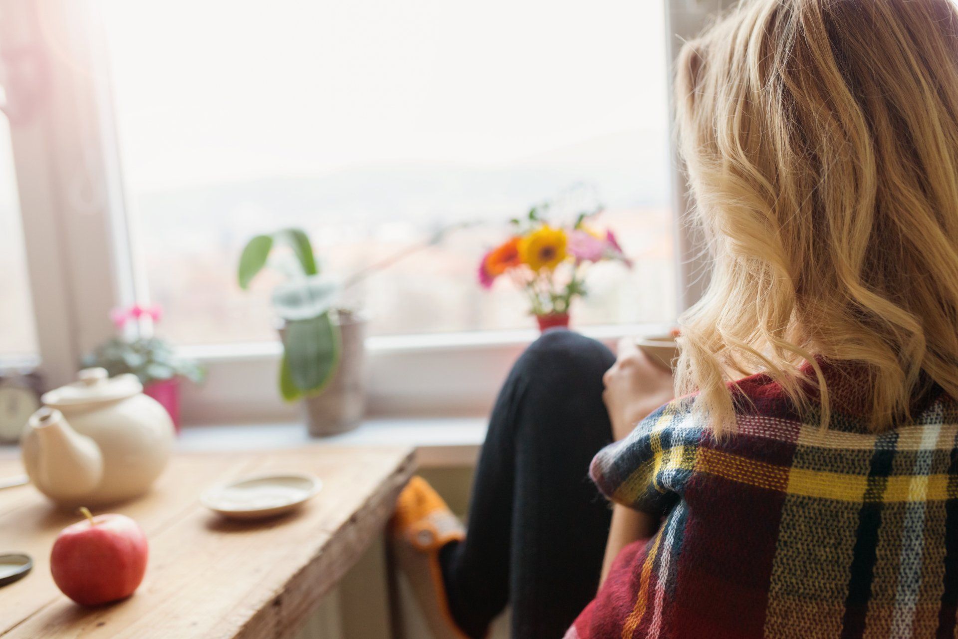 A woman drinks coffee at home