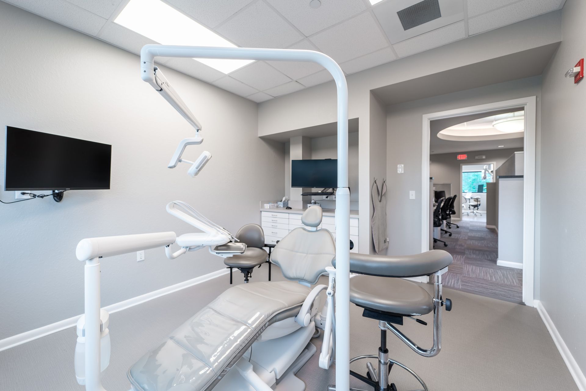 A dental office with a dental chair and a television.