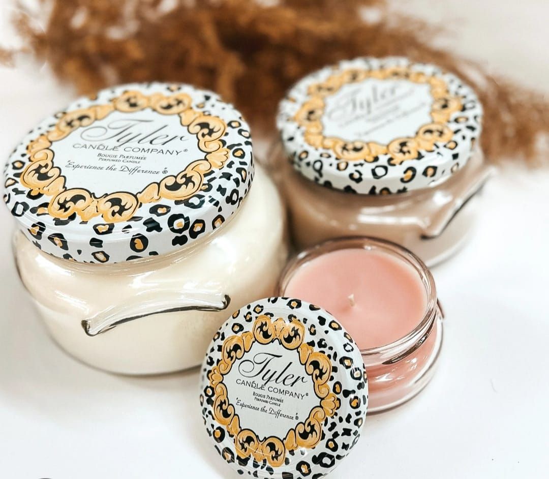 Three jars of candles with leopard print lids are sitting on a table.