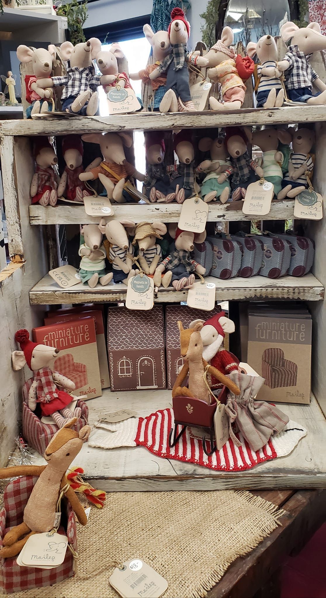 A bunch of stuffed animals are sitting on a shelf in a store.