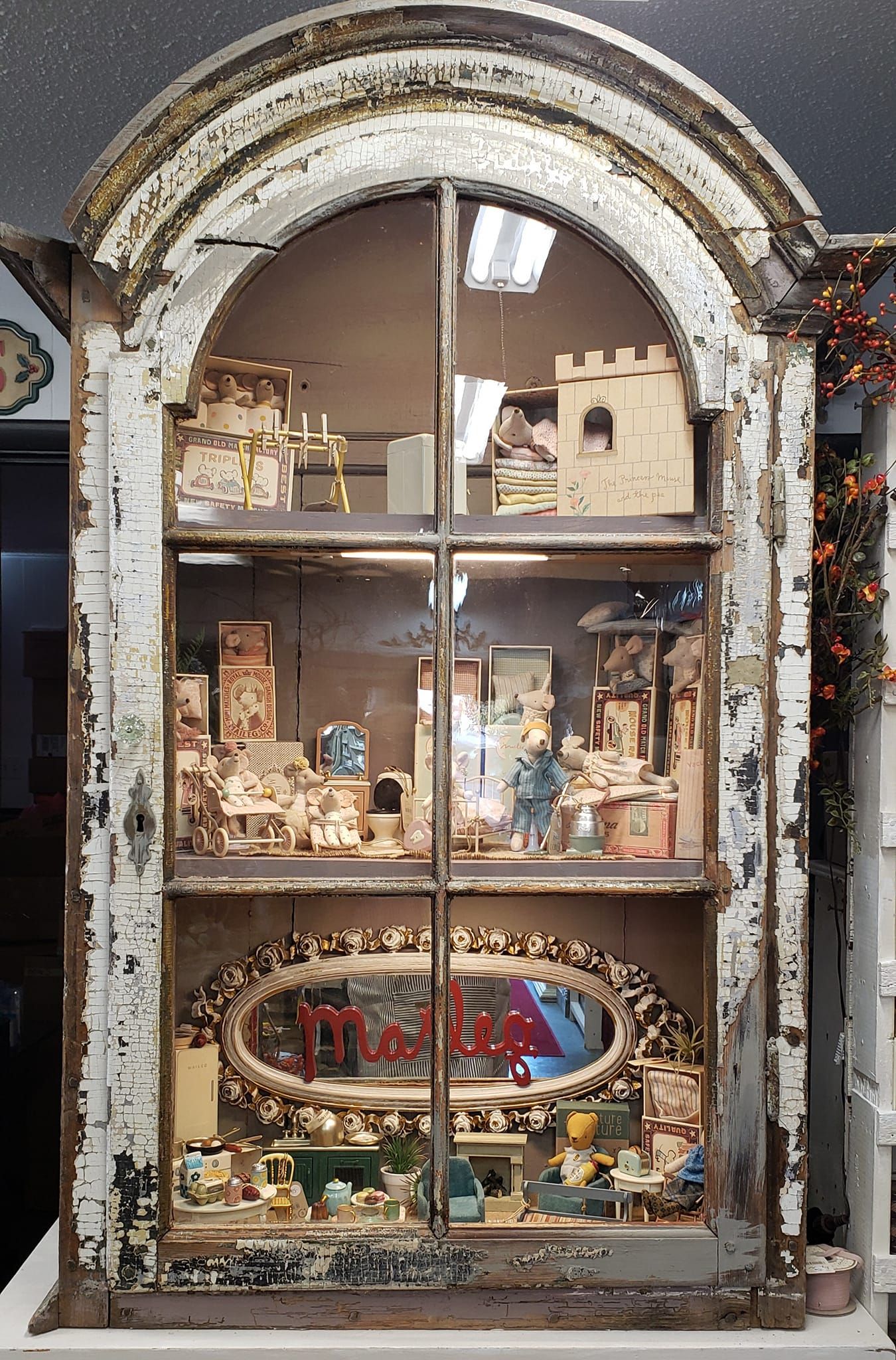 A display case with a glass door and shelves filled with various items.