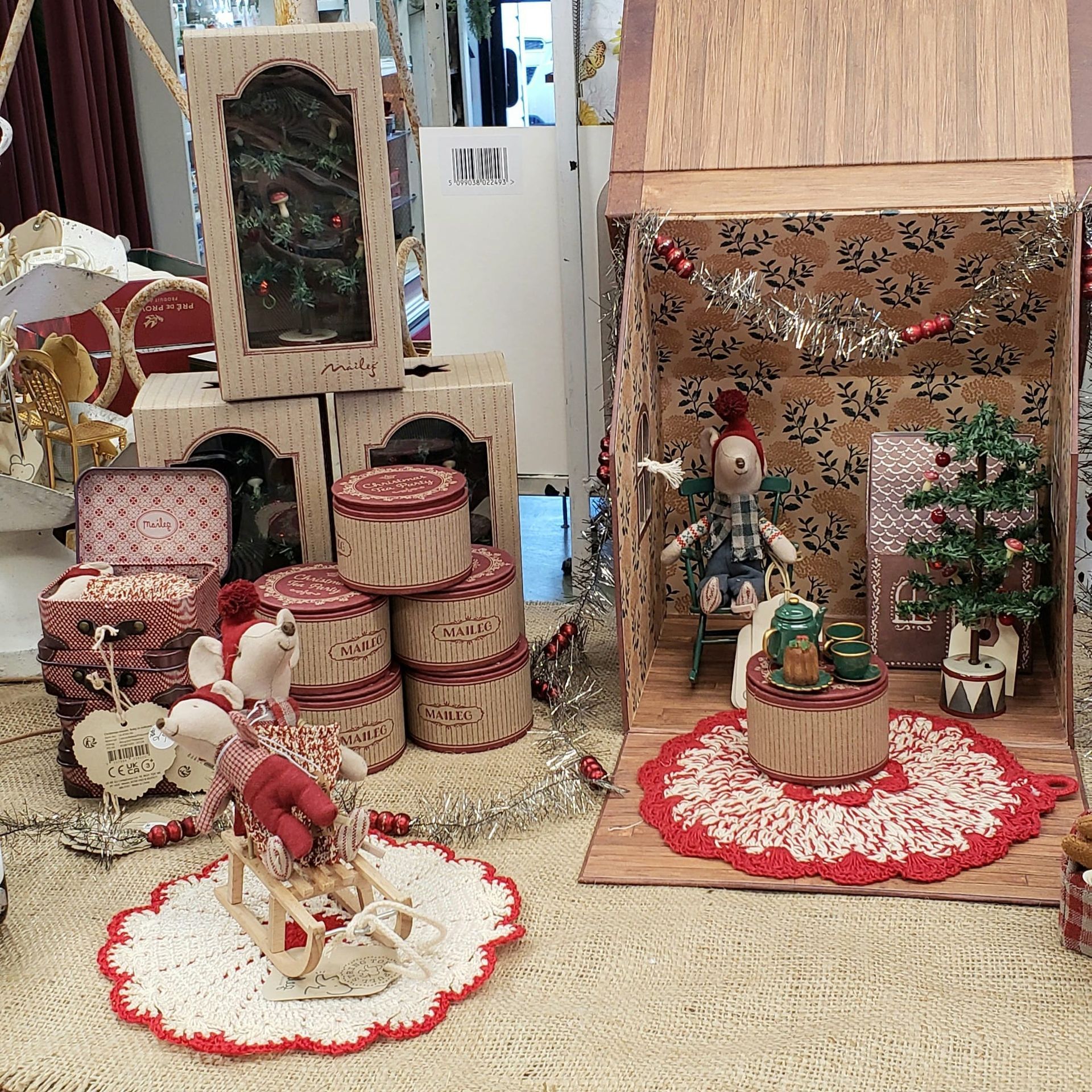 A doll house filled with christmas decorations and a christmas tree