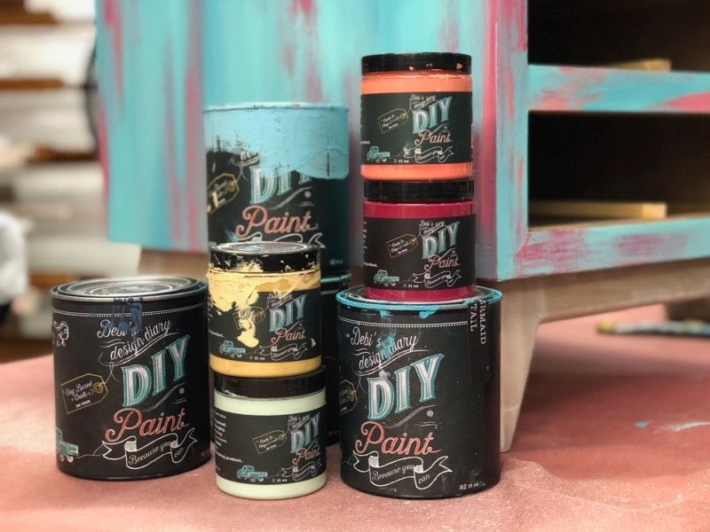 A black dresser sits in a room next to a hutch