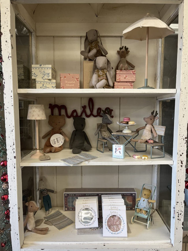 A shelf filled with stuffed animals and a sign that says mailer