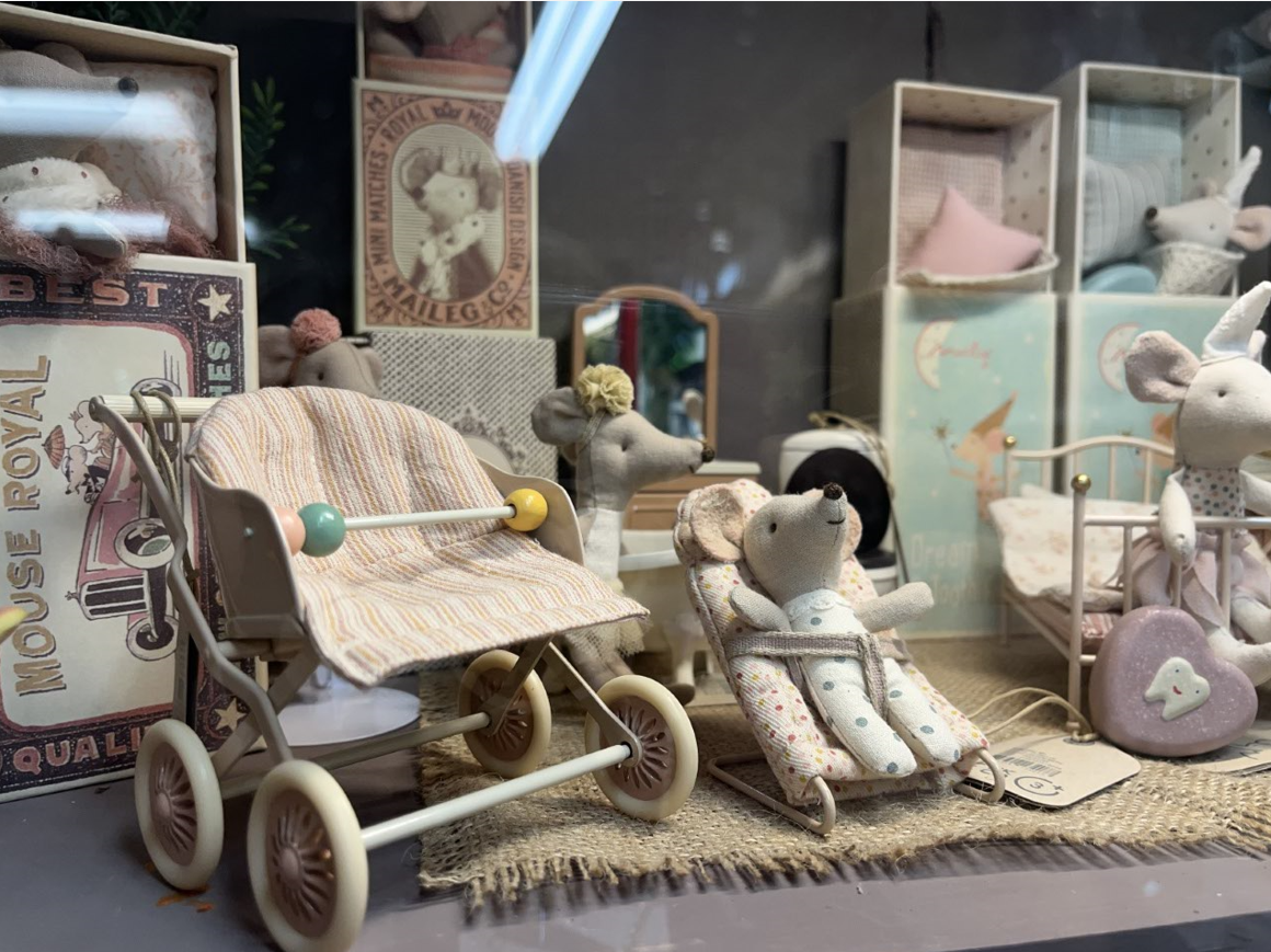 A display of stuffed animals including a baby stroller