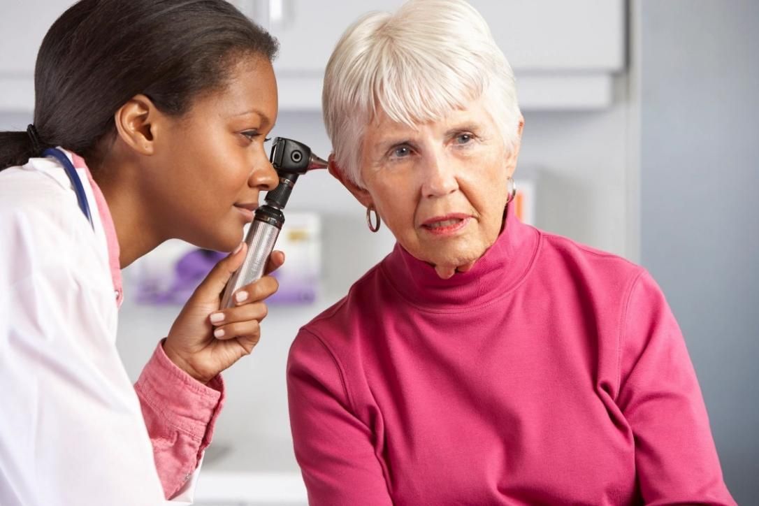Audiologist performing gentle ear wax removal for an adult patient at a hearing clinic in Ealing.