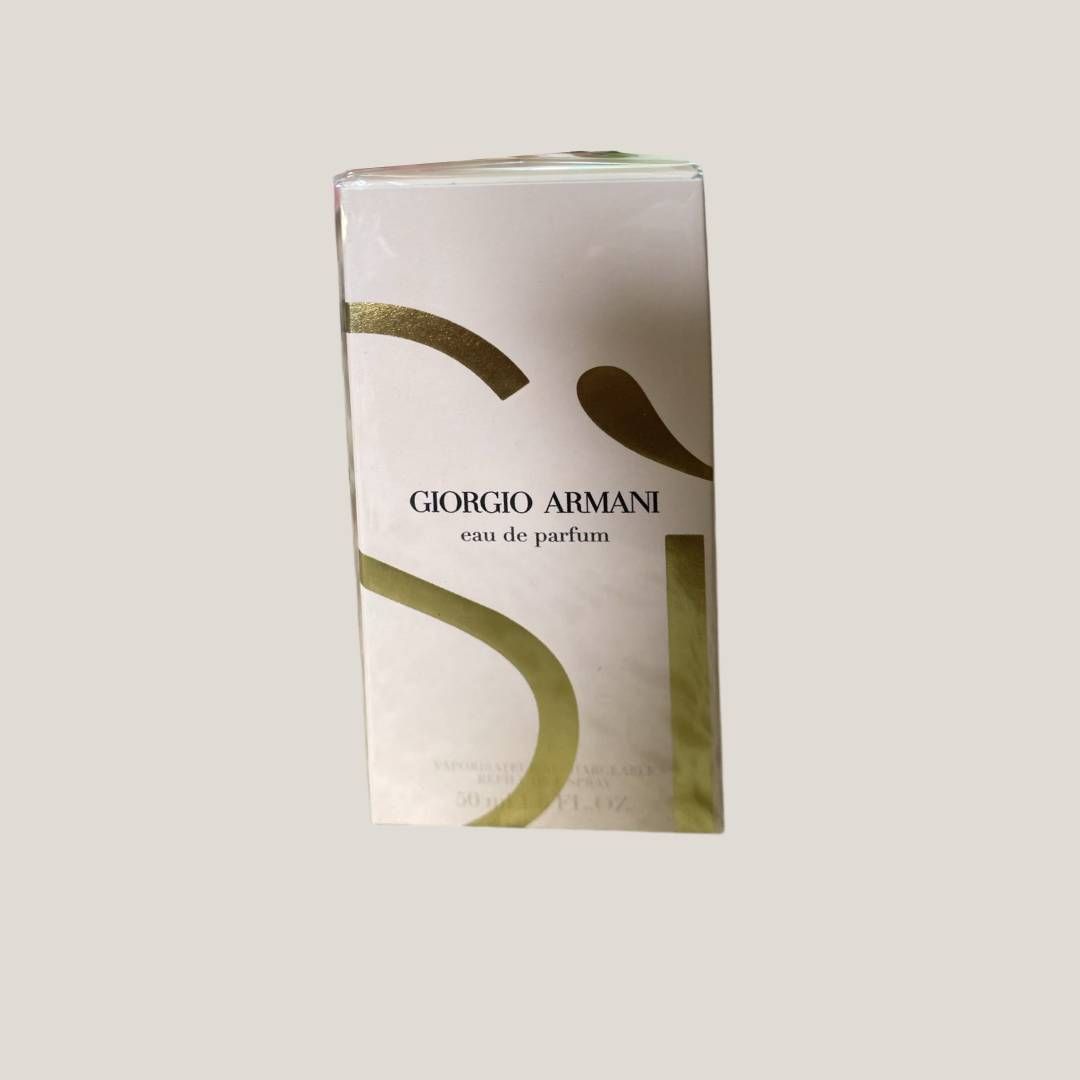 Caja de perfume Armani en blanco y dorado con un gran diseño estilizado en forma de