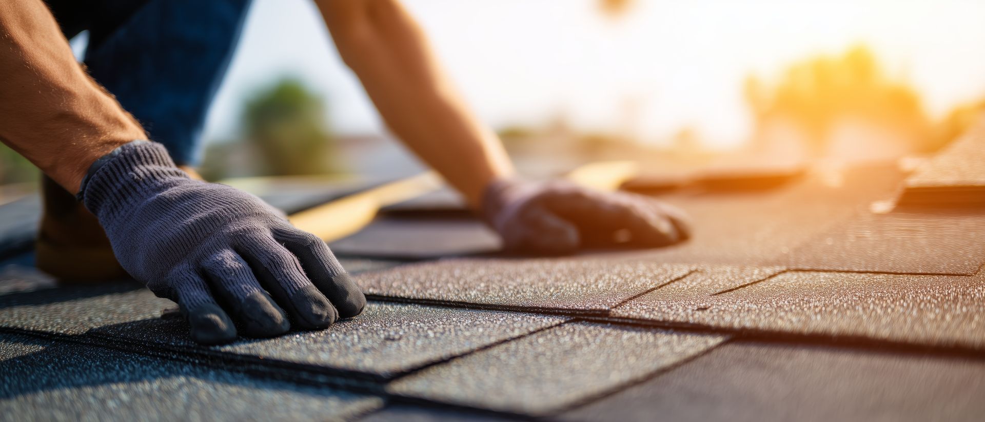 Professional roofing contractor installing new asphalt shingles on a residential house roof. Professional roofing contractor installing new asphalt shingles on a residential house roof.