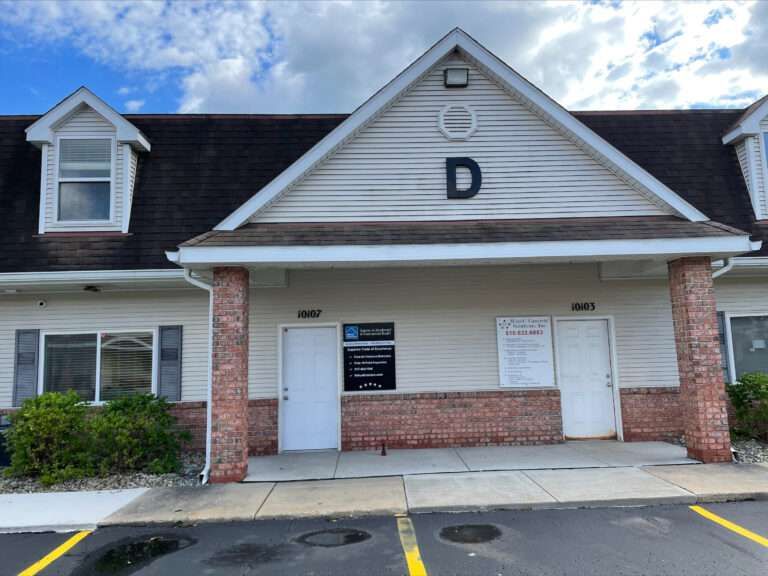 Exterior of a tan office building with brick accents and a large