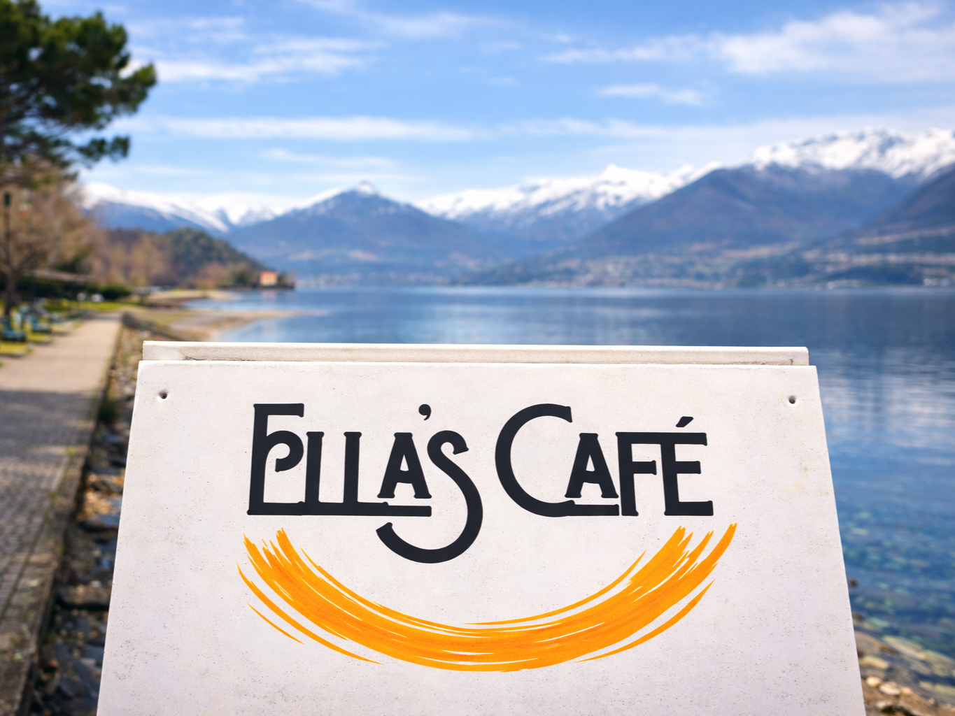 Insegna dell'Ella's Cafe con lago e montagne innevate sullo sfondo.
