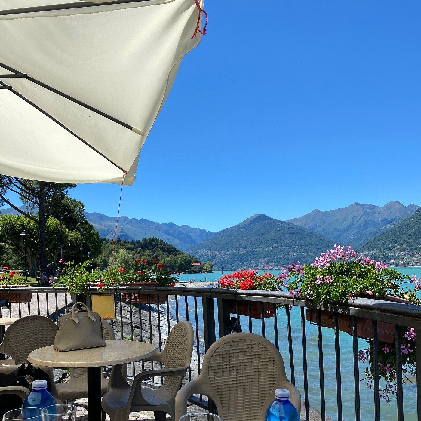 Bar all'aperto con vista sul lago e sulle montagne, sotto l'ombrellone nelle giornate di sole.