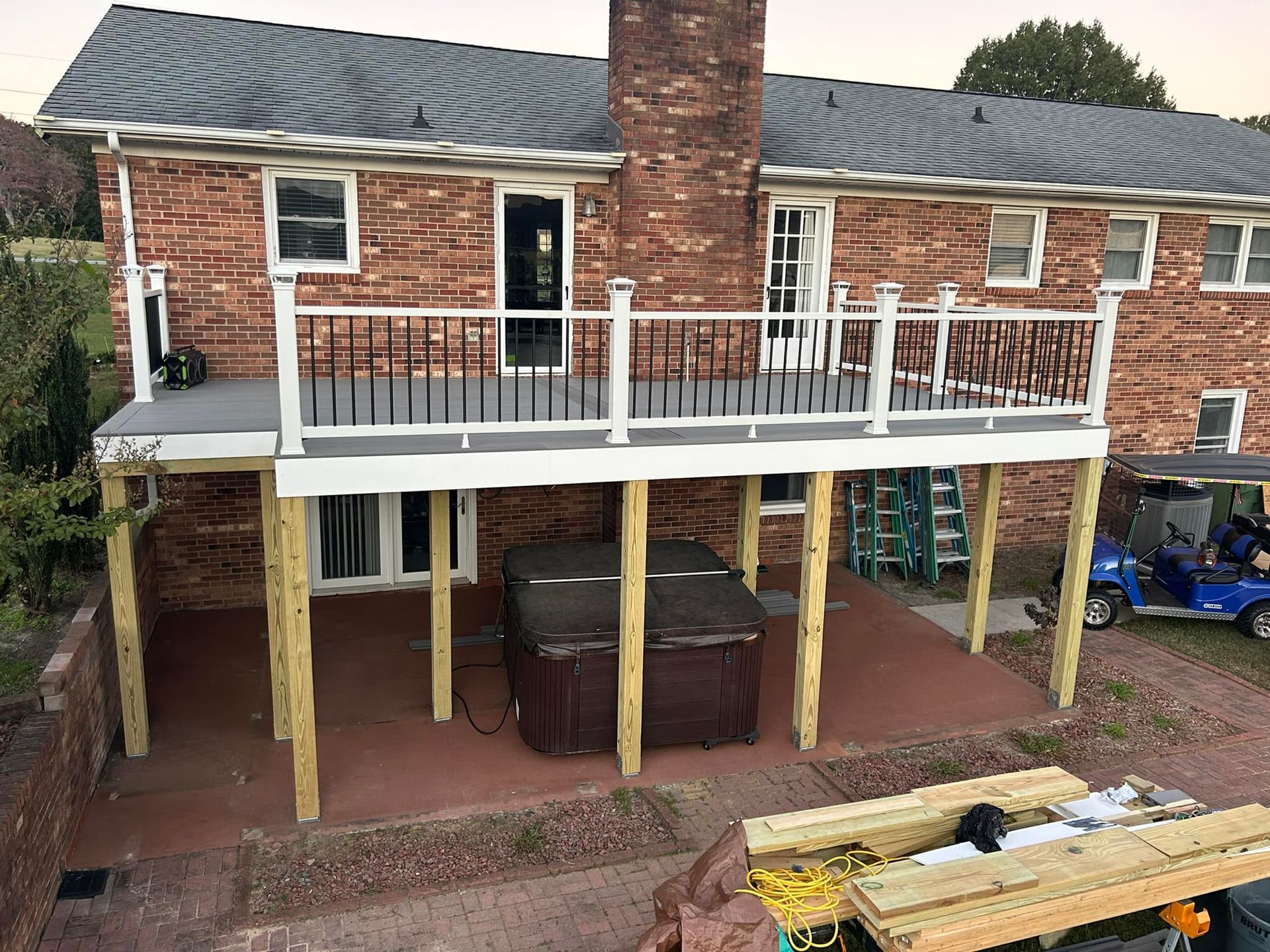 A house with a large deck and a hot tub underneath it.
