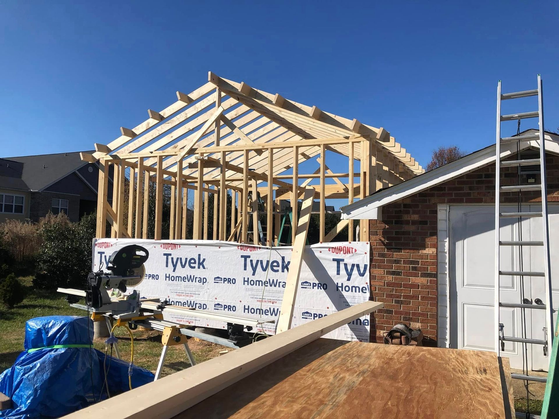 A house is being built with a ladder and a saw.