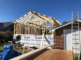 A house is being built with a ladder and a saw.