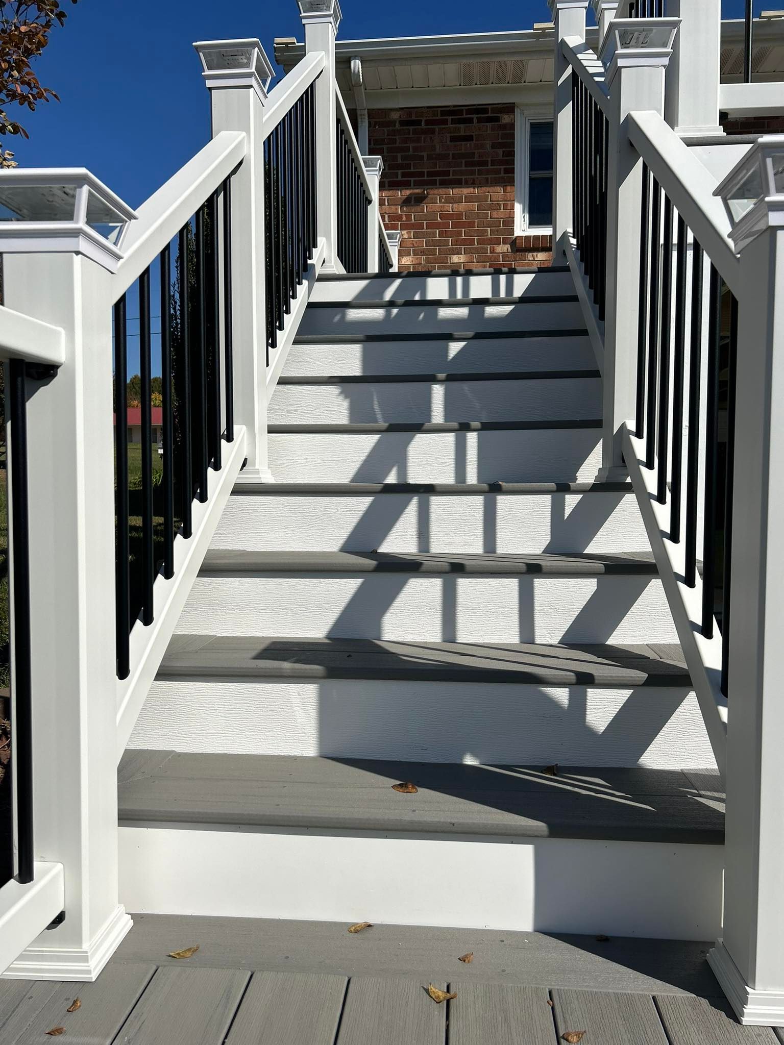 A set of stairs leading up to a house with a black railing.