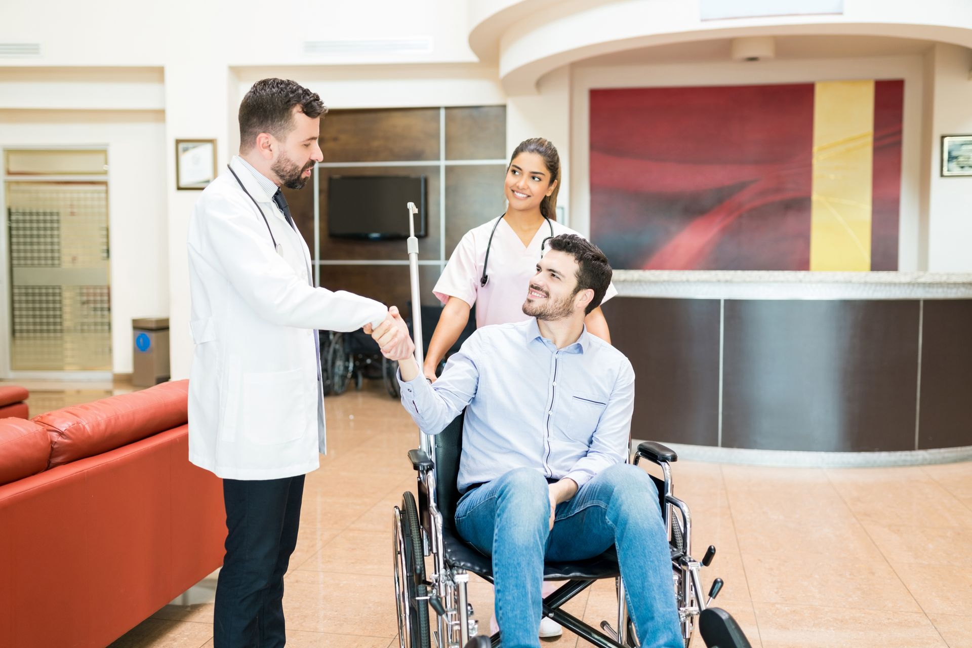 A man in a wheelchair is shaking hands with a doctor.