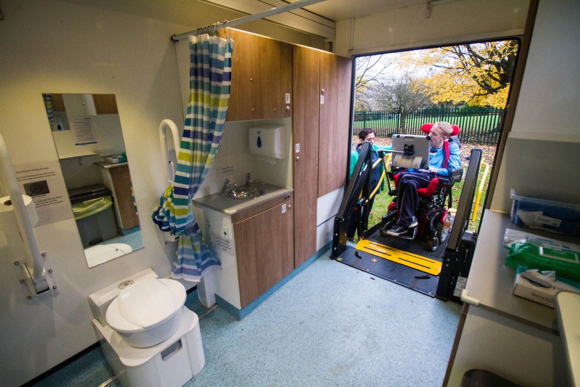 a woman in a wheelchair is getting out of a bathroom