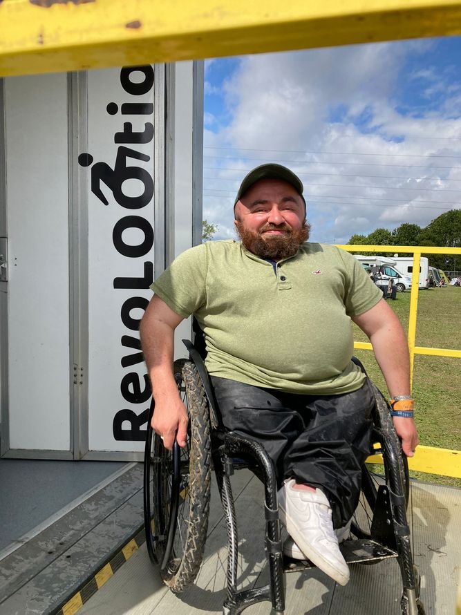 a man in a wheelchair is standing in front of a sign that says revolootion