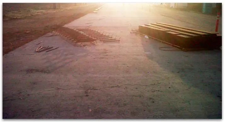 Concrete path with a long, rectangular object to the right; light source in the top background.