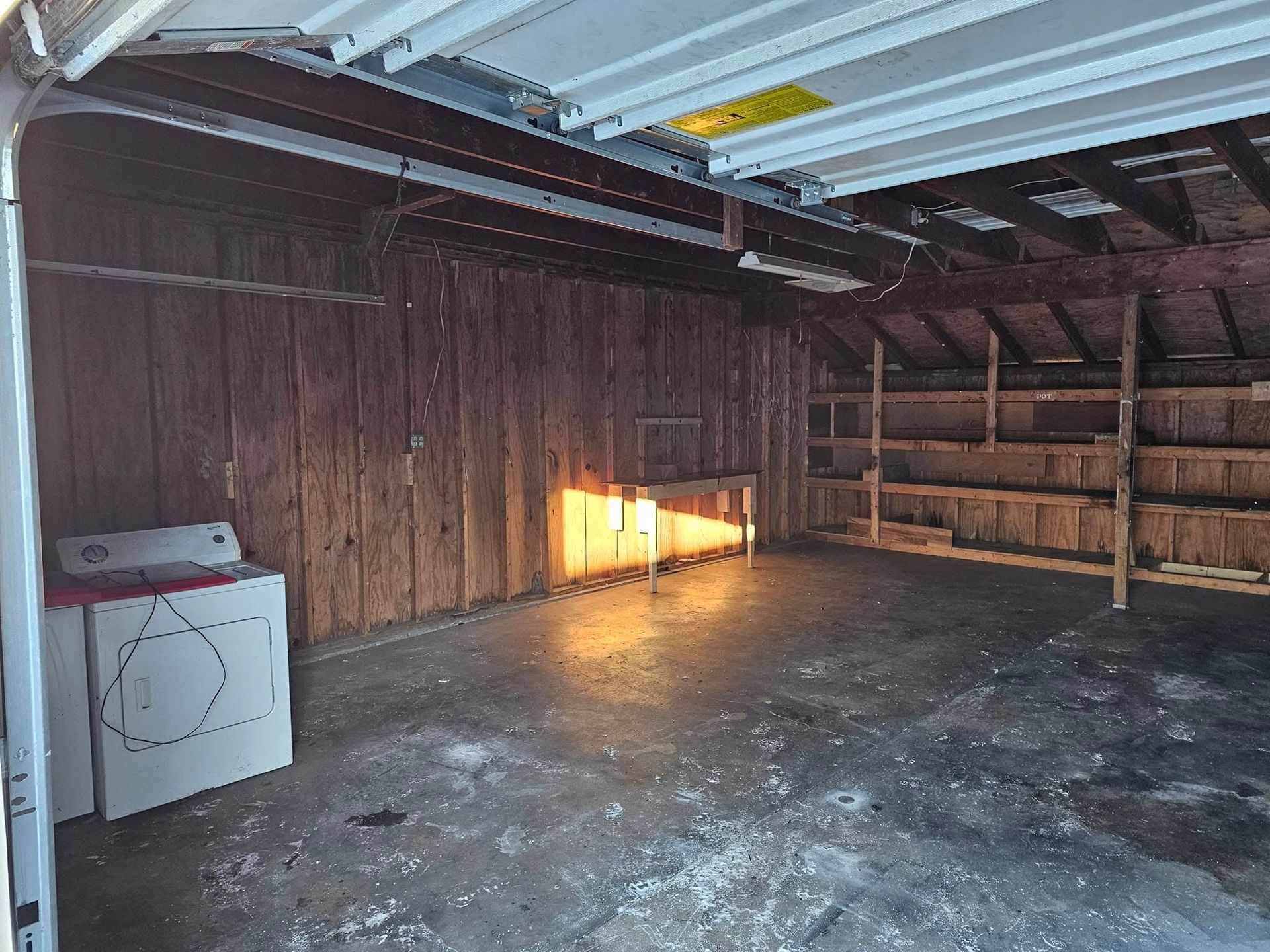 An empty garage with a washer and dryer in it.