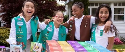 image of four Girl Scouts selling cookies who aren't afraid of hearing the word