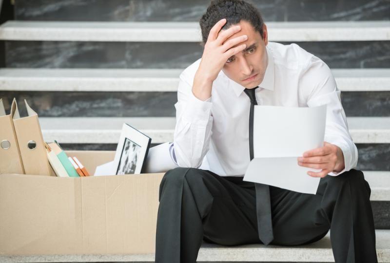 professionally-dressed male trying to figure out what to do after being laid off from his job