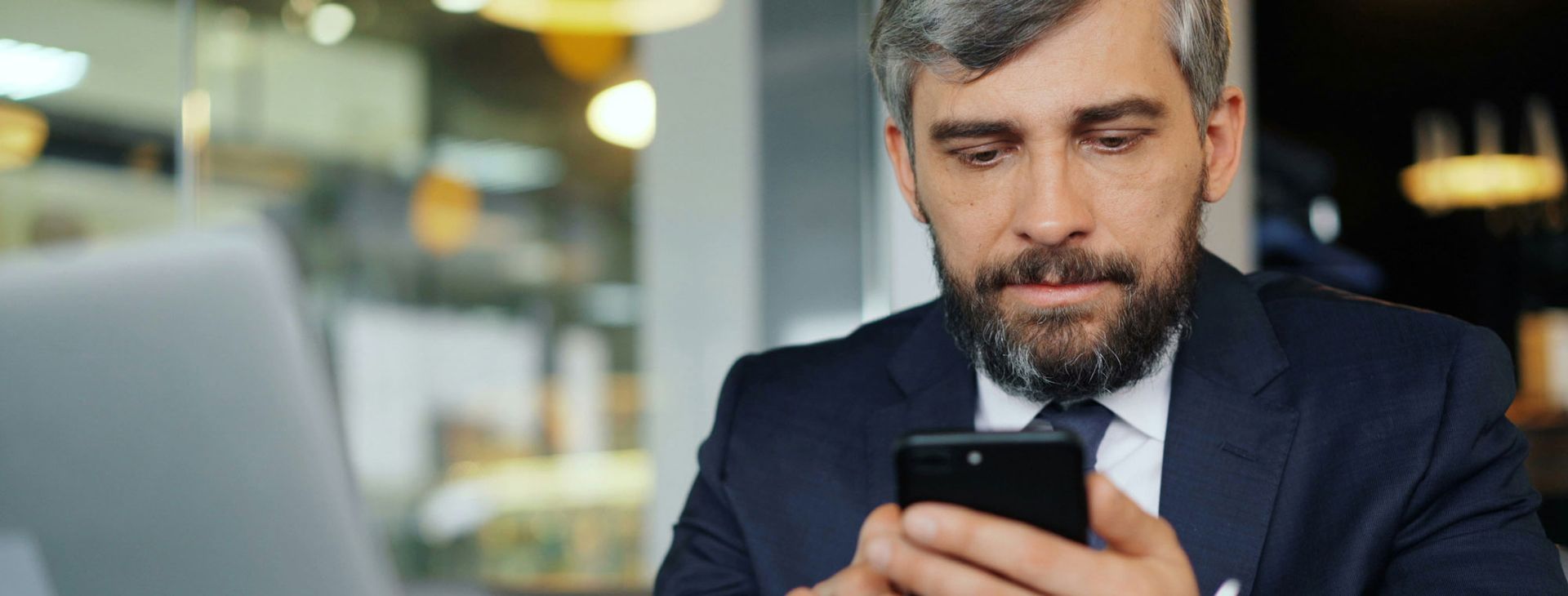 Executive male looking at phone and looking at Endeavor Agency's website.