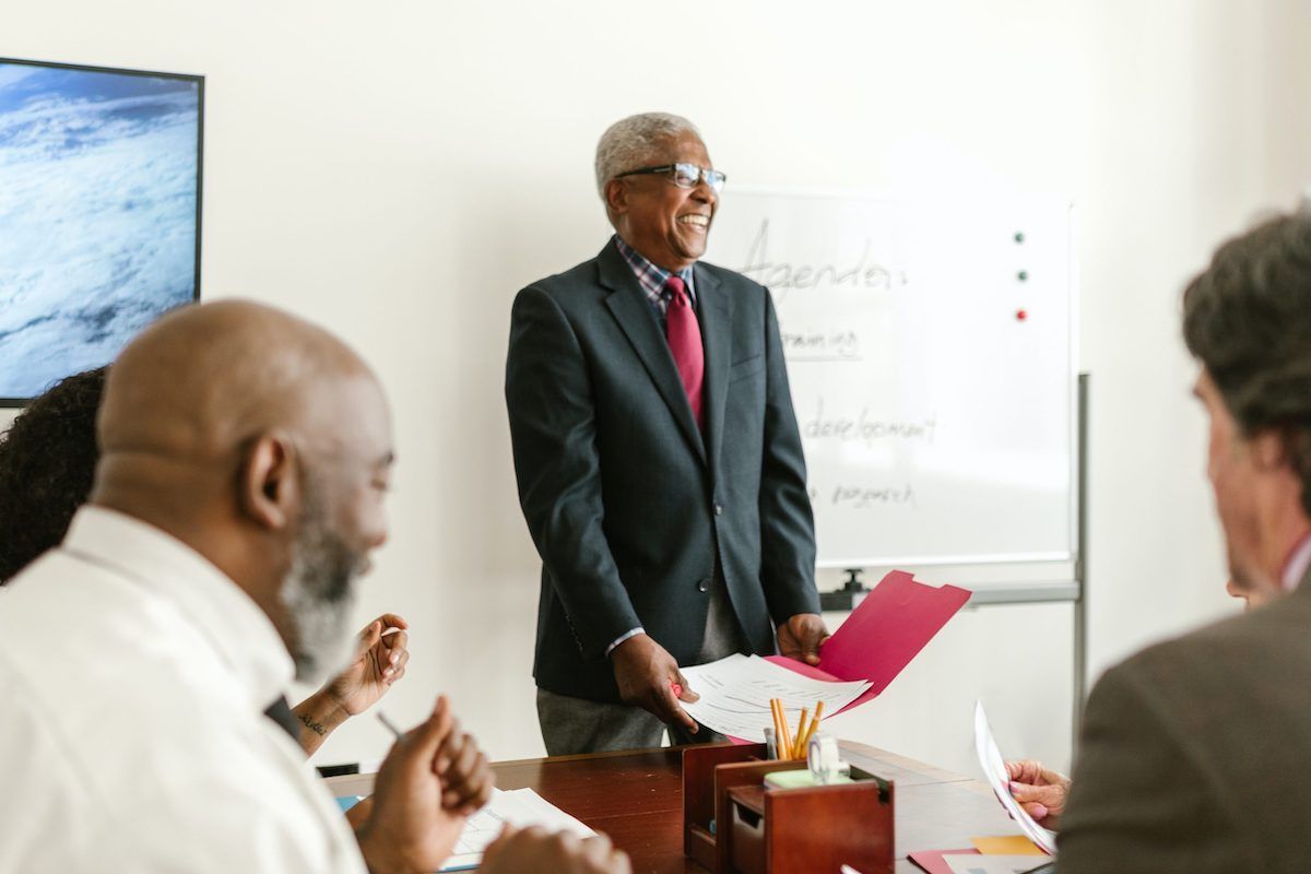 male executive in front of group of people interviewing him