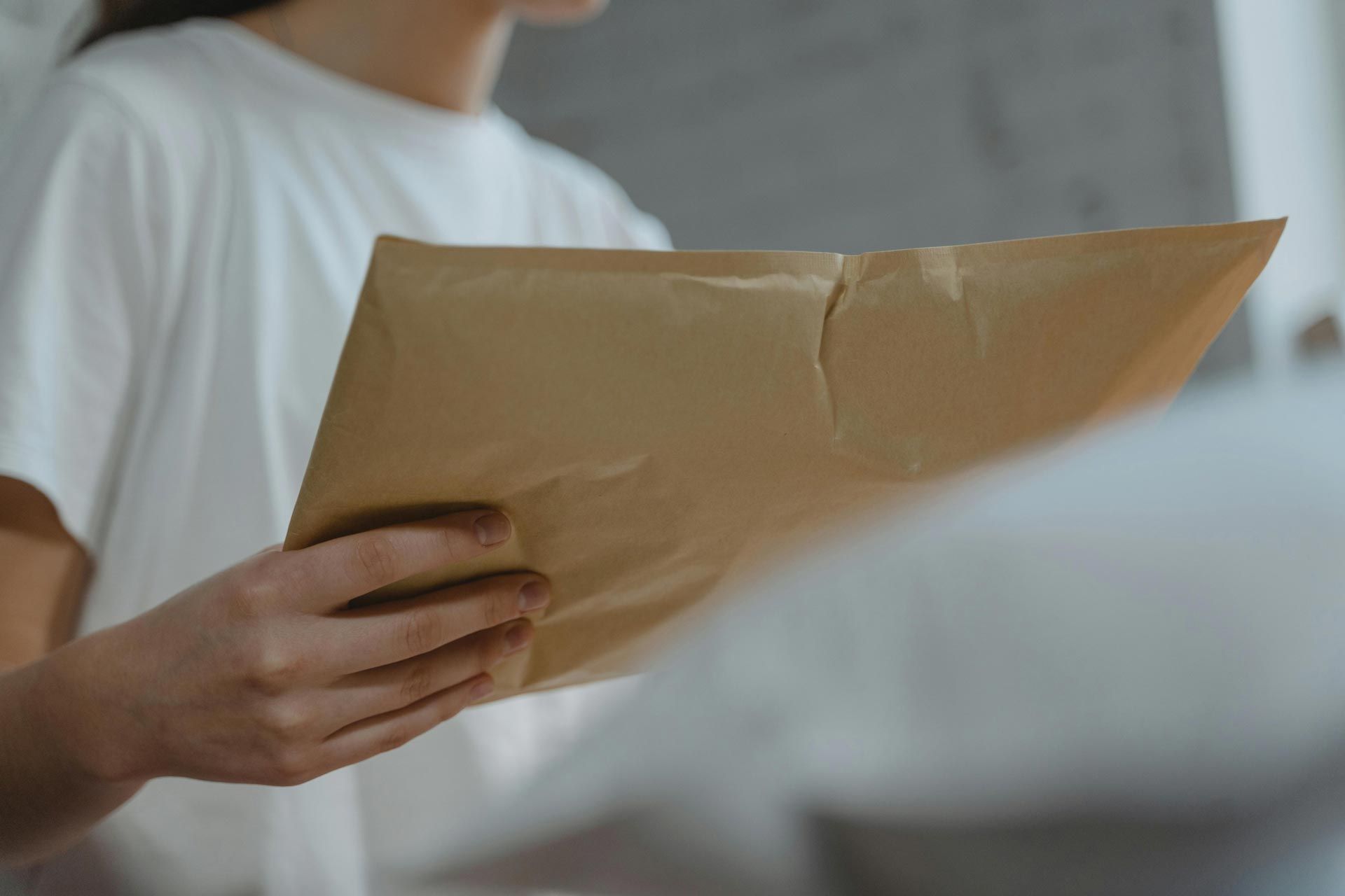 woman mailing resume and cover letter in big brown envelope