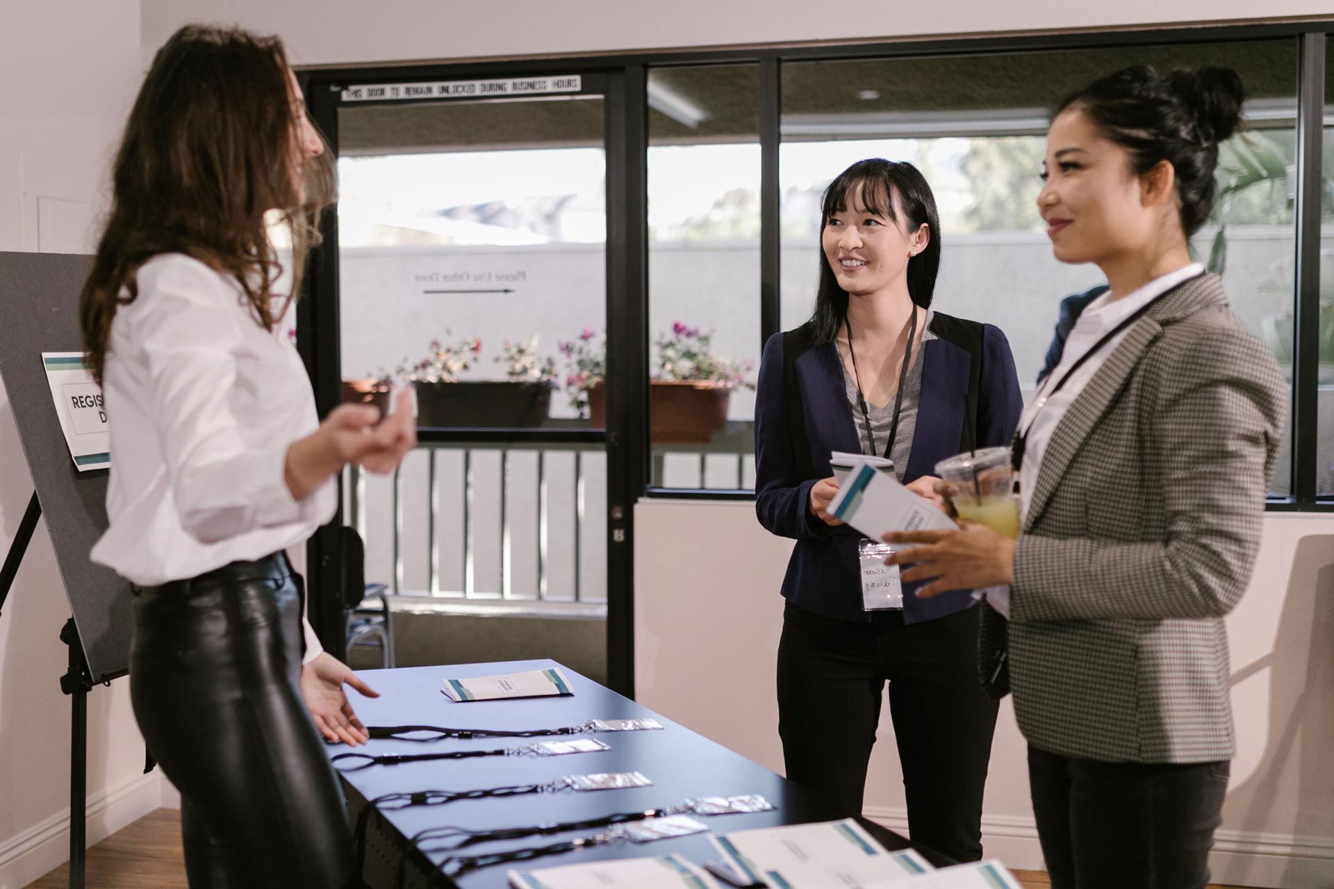 Two female students checking in at the registration table for their college's career fair.