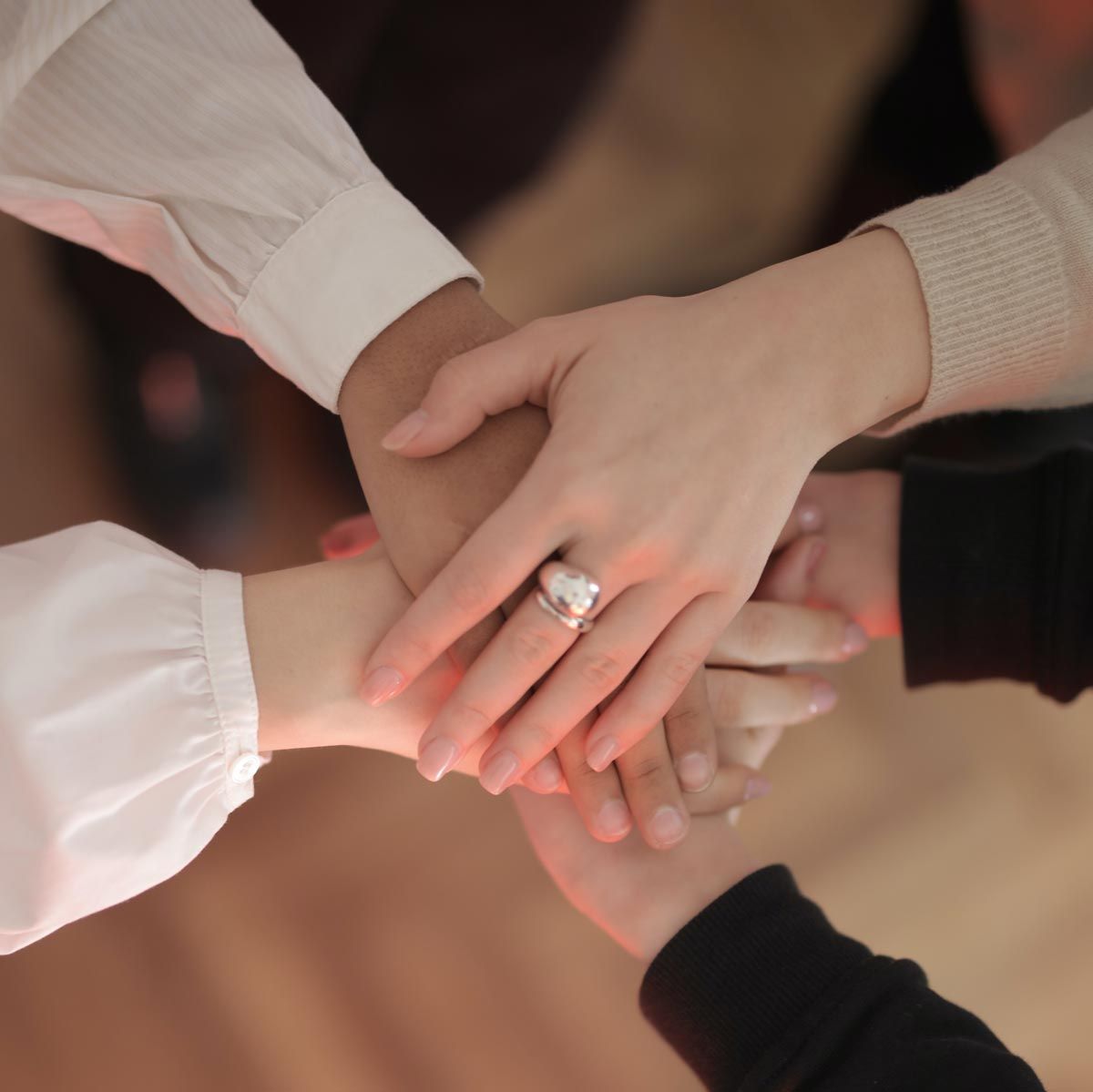 hands in huddle signifying you are not alone in your executive job search