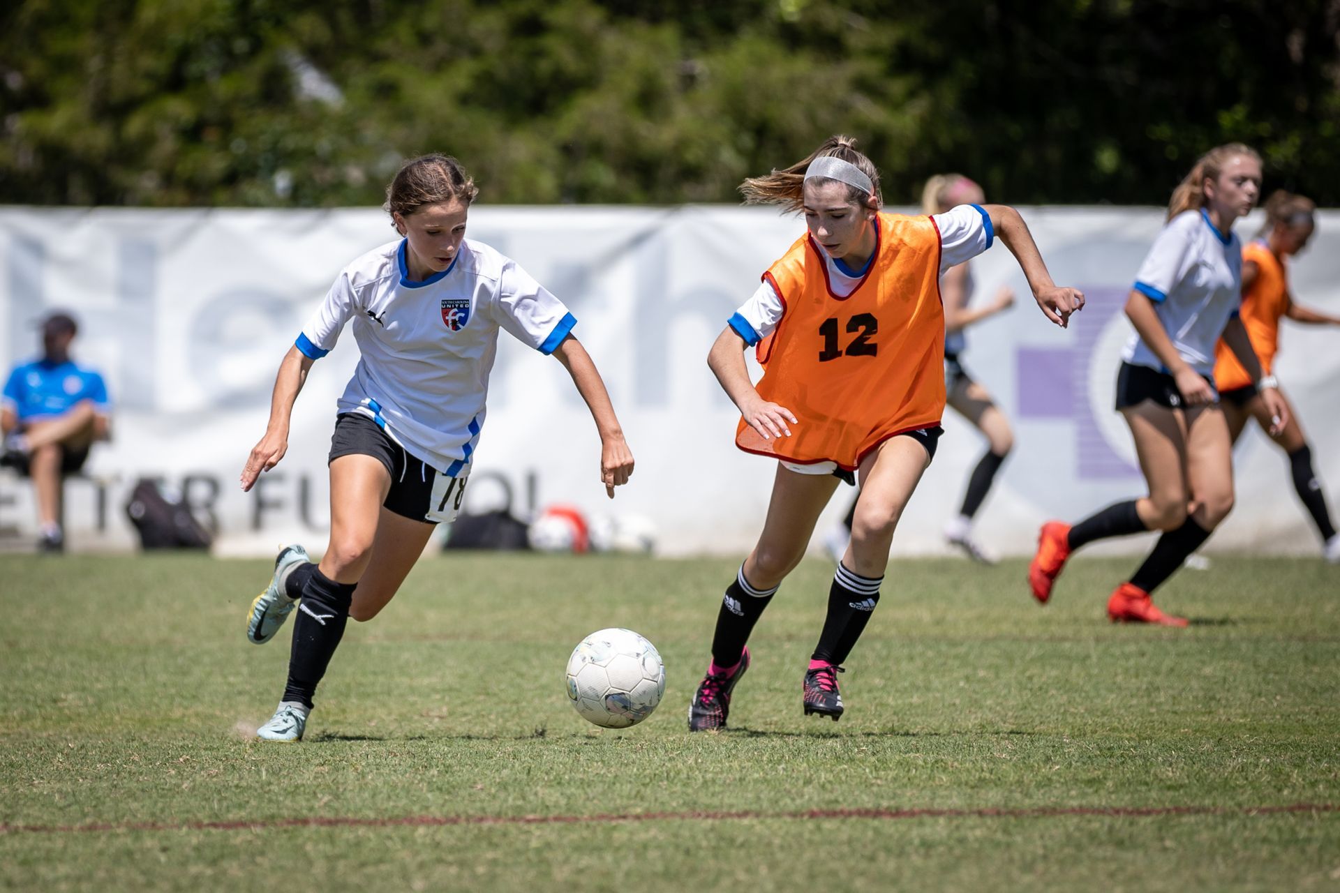 A group of young girls are playing soccer on a field for South Carolina United FC.