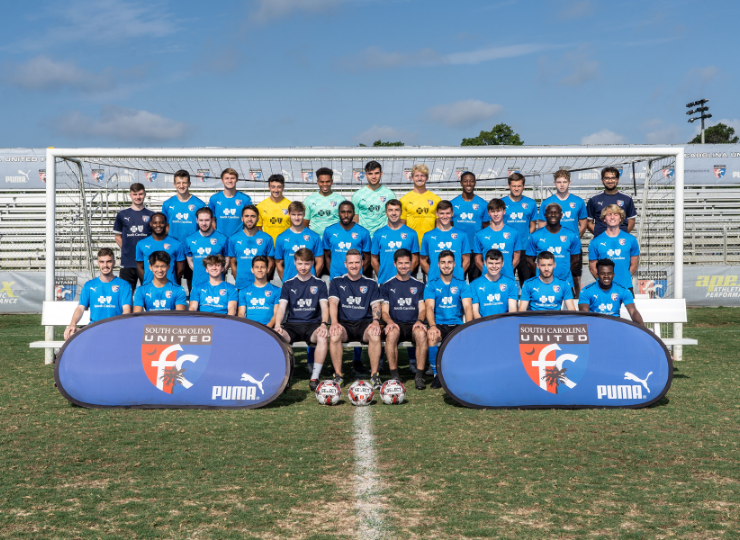 A group of soccer players are posing for a team photo