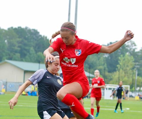 A female soccer player in a red South Carolina United FC jersey.
